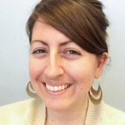 Breanne LeJeune is wearing funky earrings and a yellow cardigan.